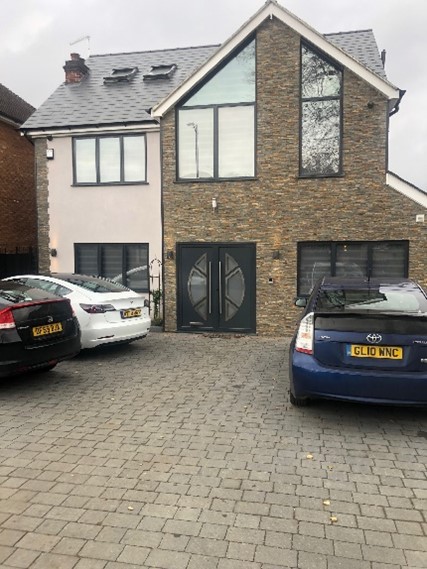 A couple of cars parked in front of a house

Description automatically generated with medium confidence